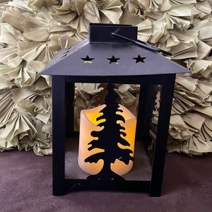 Battery-operated lantern with pine tree silhouette